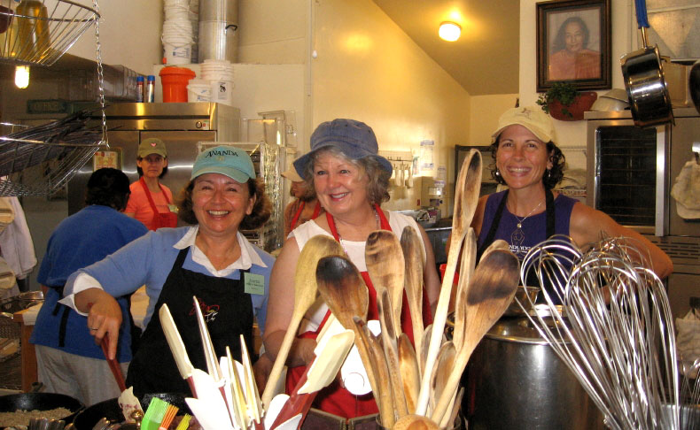 ladies smiling while cooking at the Expanding Light Retreat