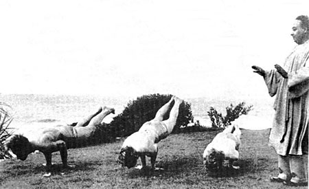 Paramhansa Yogananda blessing several of his monastic disciples as they practice Mayurasana (Peacock Pose).