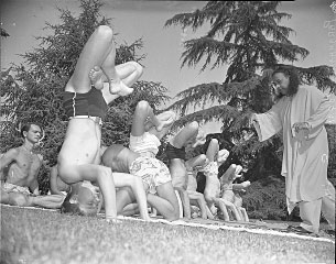 Paramhansa Yogananda guiding monastic disciples in Padma Sirshasana (Headstand in Lotus Pose) and meditation. Swami Kriyananda is the young man meditating behind the others doing the asana.