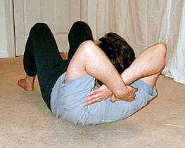 Student sitting up with arms crossed behind his head