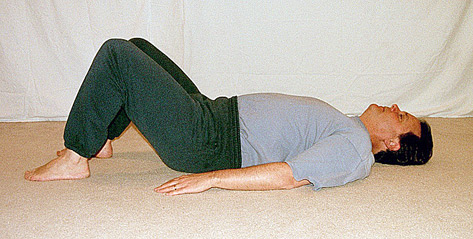 Man lying down with feet on the floor and knees raised