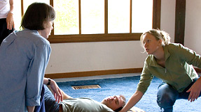 A young woman teaching a restorative yoga pose