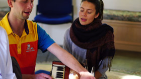 Karma Yoga spiritual interns practicing harmonium Karma Yoga spiritual interns during dining room service