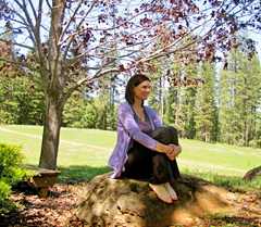 Lady breathing deeply and releasing stress while sitting on a rock