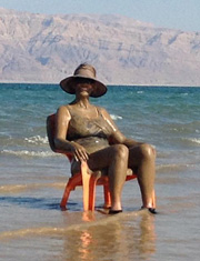 Relaxing at the Dead Sea covered with mineral mud